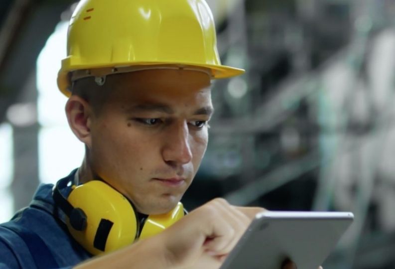 Das Bild zeigt einen Mitarbeiter der ein Tablet mit der Check-it App benutzt.